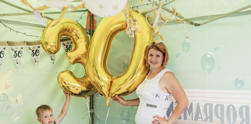 A cheerful 30th birthday party featuring gold balloons and decorations.